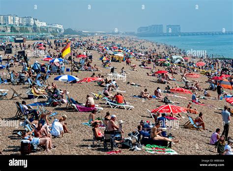 People Flock To The Beach In Brighton To Sunbathe And Swim In The Record Breaking Hot