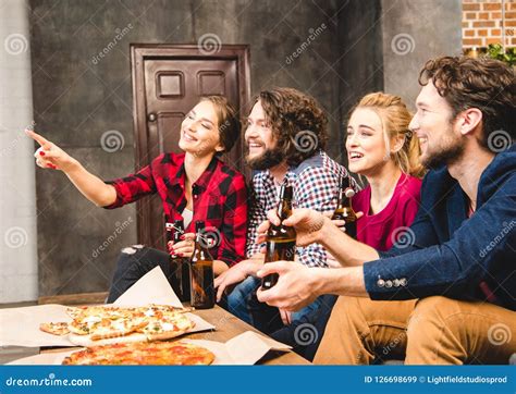 smiling friends drinking beer and eating pizza while sitting stock image image of drink women