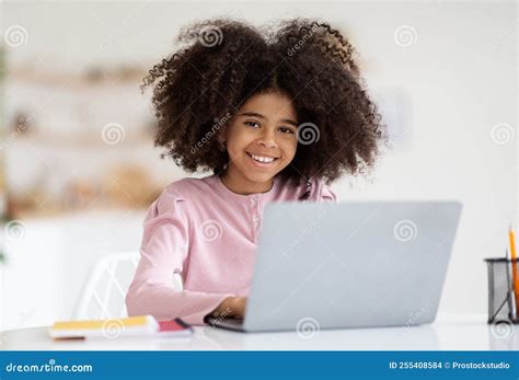 Smiling African American Girl Typing On Laptop Keyboard Stock Photo