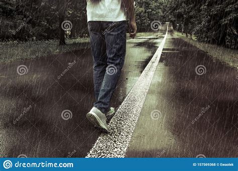 A Man Walking Alone In The Rain On A Park Alley Stock Photo Image Of