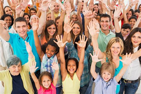 Group Of Happy People With Arms Raised Looking At Camera Stock Photo