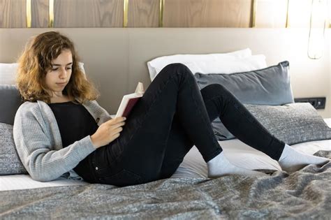 chica adolescente leyendo un libro en la cama foto premium