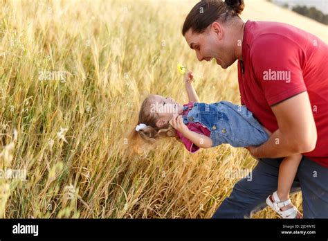 happy father playing and carrying his daughter on hands mature man playing with his little