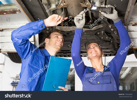 Car Mechanics Repairing Car On Hydraulic Stock Photo 133920200