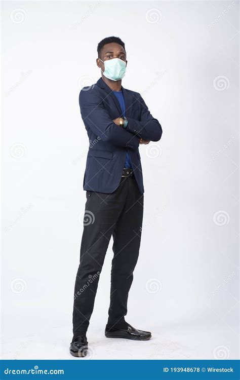 Black Businessman Wearing A Suit And Face Mask Standing With Arms