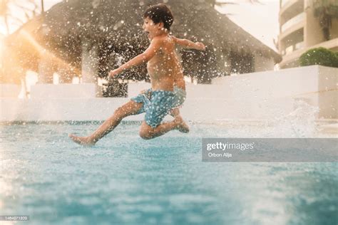 Boys Jumping Into The Pool High Res Stock Photo Getty Images