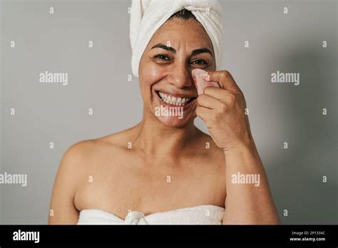 Happy Latin Woman Massaging Facial Skin With Jade Gua Sha People