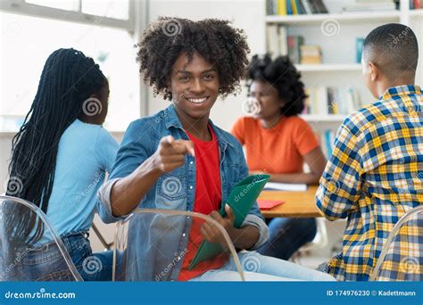 Happy African American Male College Student At Desk At Classroom Foto