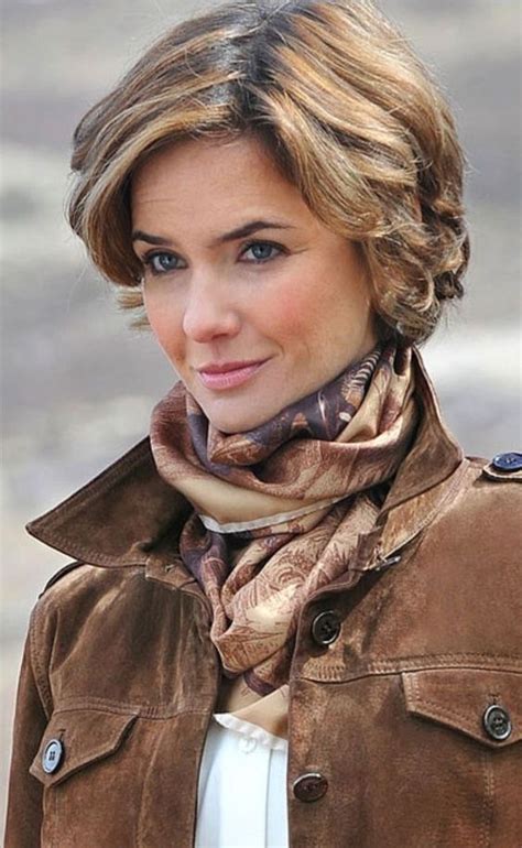 a woman wearing a brown jacket and scarf