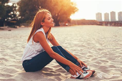 Young Happy Woman Sitting On The Beach Sand And Smiling Young Happy Woman Sitting On The Beach