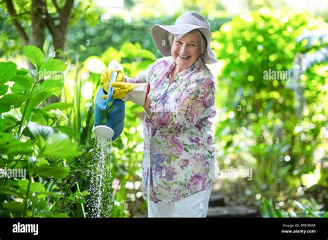 Portrait Of Senior Woman Watering Plants Stock Photo Alamy