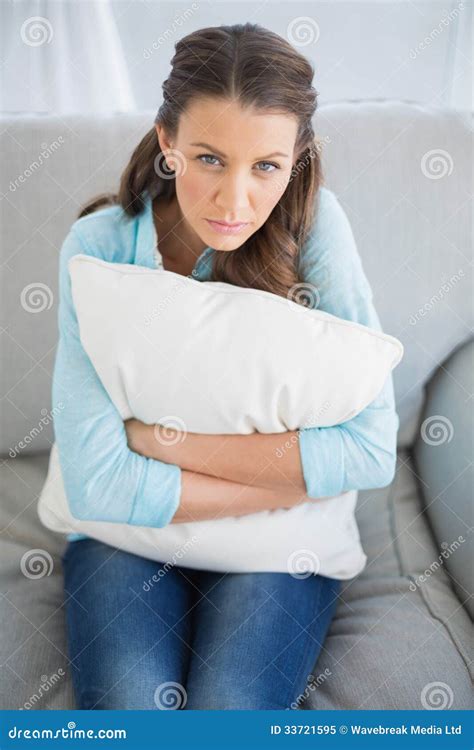 Relaxed Woman Sitting On Sofa Holding Pillow Royalty Free Stock Photo