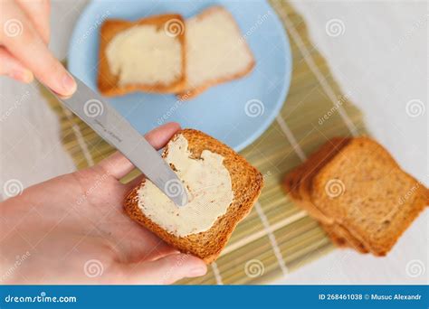 A Person X S Hands Delicately Spreading Butter On A Piece Of Freshly