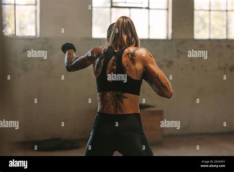 Woman In Sportswear Practicing Shadow Boxing At A Fitness Space Inside Abandoned Warehouse