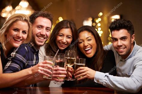 Group Of Friends Enjoying Drinks In Bar — Stock Photo © Monkeybusiness