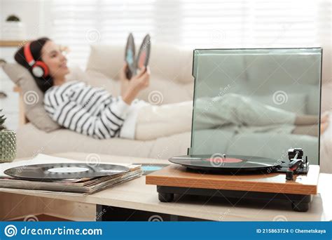 Woman Listening To Music With Turntable In Living Room Stock Photo