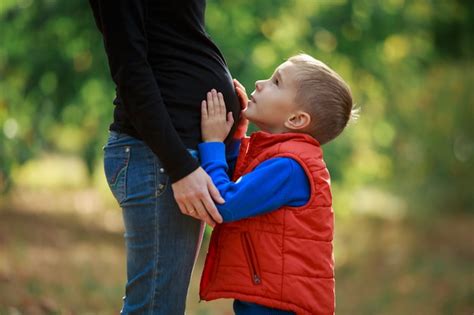 Pequeño Hijo Abraza A Su Mamá Embarazada Panza En La Naturaleza Niño