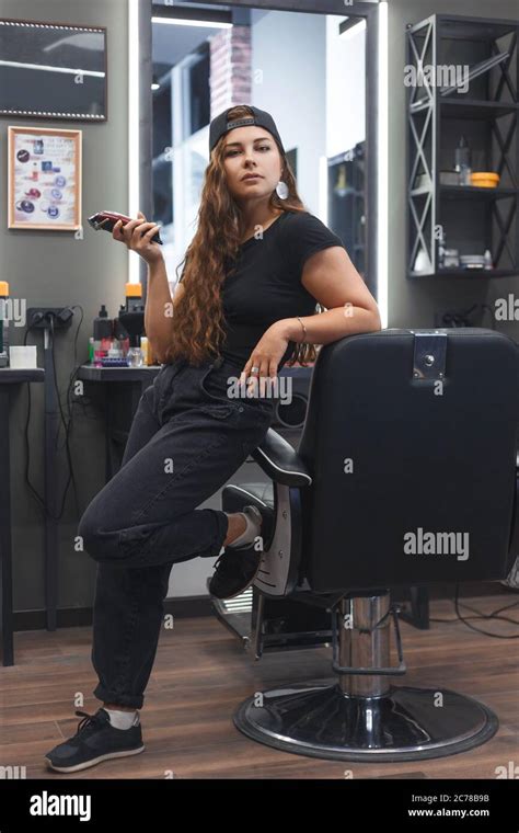 Young Caucasian Barber Woman Holding A Hair Clipper And Standing At