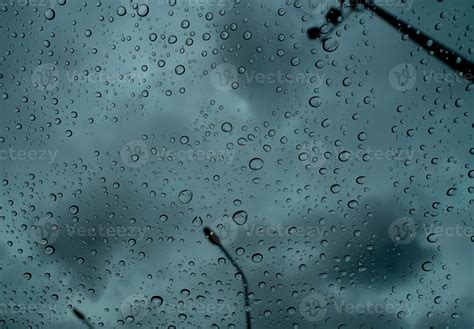 Raindrops On Transparent Glass Against Blur Dark Stormy Sky And