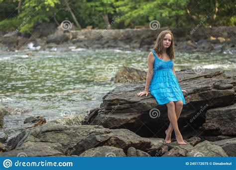 Una Adolescente Sentada Sobre Las Rocas En Una Playa Tropical Imagen De Archivo Imagen De