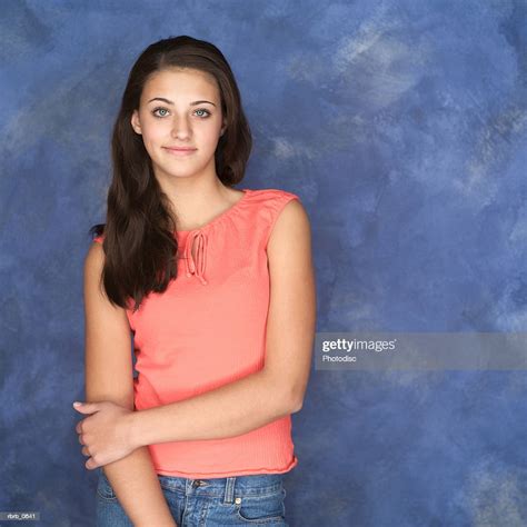 Portrait Of A Cute Ethnic Teenage Girl In An Orange Tank Top Smiles