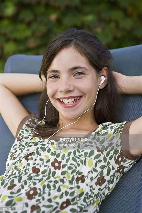 Smiling Preteen Girl With Earbuds Photo Getty Images
