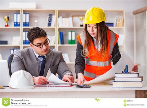 The Construction Foreman Supervisor Reviewing Drawings Stock Photo