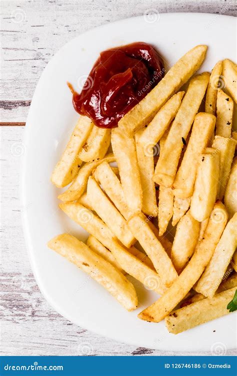 White French Fries Plate With Ketchup And Parsley On White Table Stock