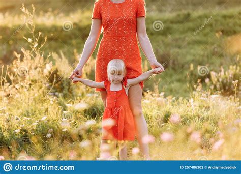 Portrait Of A Mother Holds Throws Up And Spins The Daughter On Hands