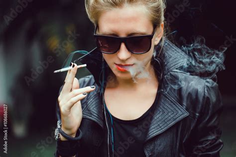 Young Beautiful Girl In A Leather Jacket Blonde With Red Lips Smoking A