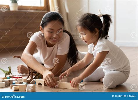 Asian Young Mom And Little Daughter Play Building Bricks Stock Photo