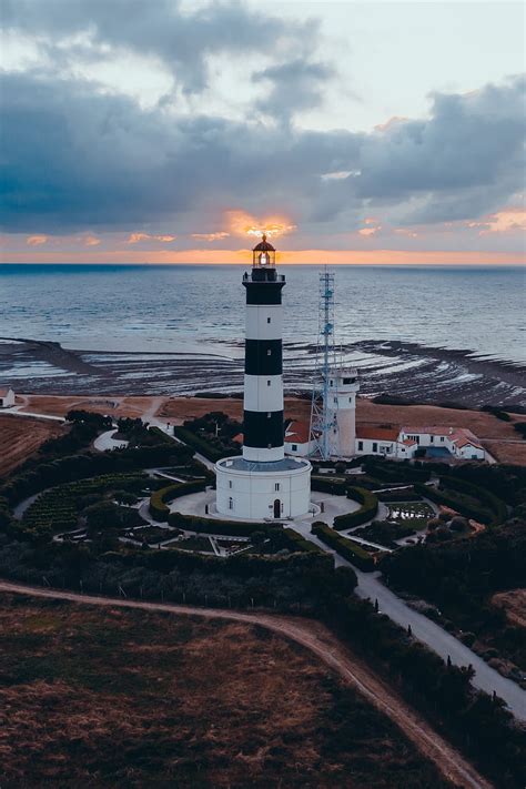 Lighthouse Building Sea Sunset Horizon Hd Phone Wallpaper Peakpx