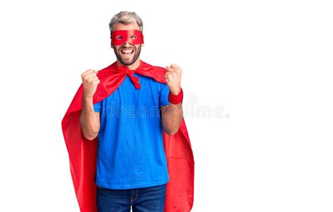 Young Blond Man Wearing Super Hero Custome Celebrating Surprised And