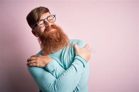 Handsome Irish Redhead Man With Beard Wearing Glasses Over Pink