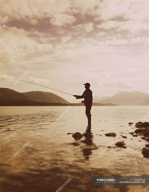 Silhouette Of Man Fishing — Mountain Bay Stock Photo 126355644