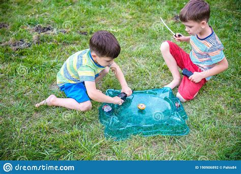 Two Boys Playing With A Spinning Top Kid Toy Popular Children Game