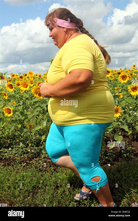 Overweight Woman Running Along Field Of Sunflowers Stock Photo Alamy
