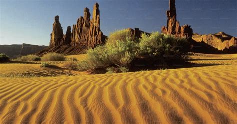 A Desert Landscape With Rocks And Grass In The Foreground Photo