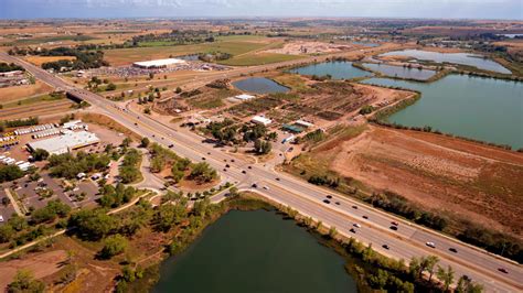 Aerial Photography Of An Open Road With Cars Near City And Lake During