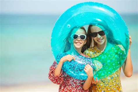 little happy funny girls have a lot of fun at tropical beach playing together stock image