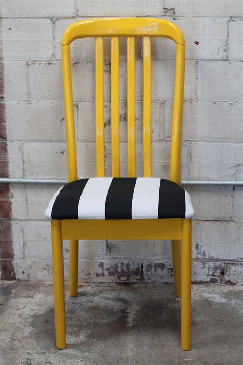 A smattering of verdant greenery adds to the natural, organic appeal of the space. Walrus: Yellow Painted Chair with Black and White Striped Seat