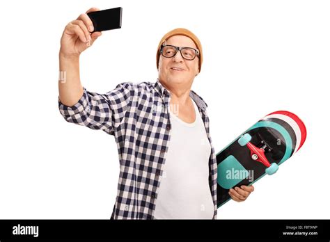 Senior Skater Holding A Skateboard And Taking A Selfie With His Cell Phone Isolated On White