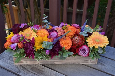 Colorful Long And Low Table Centerpiece With Lots Of Floral Goodies