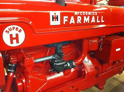 An Old Red Farmall Tractor Parked In A Garage