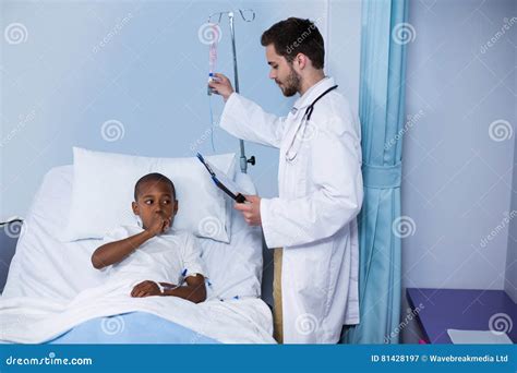 Doctor Adjusting Iv Drip While Patient Lying On Bed Stock Image Image