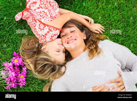 Beautiful Mother And Daughter Lying Together Outside On Grass Happy Intimate Moment Cute
