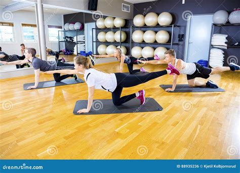 Focused Group Exercising Core Strength And Balance At Fitness Gym Stock