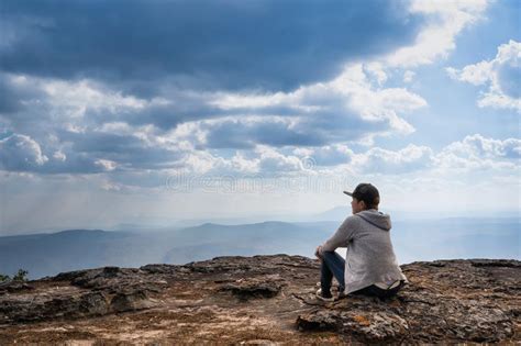 A Person Sitting On Rocky Mountain Looking Out At Scenic Natural View