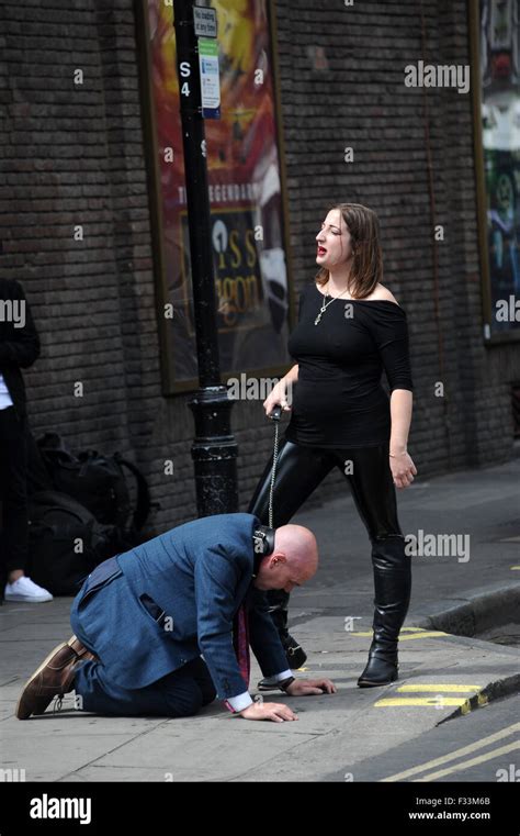 A Man Being Publicly Humiliated By A Dominatrix In The Streets Of Soho Where He Was Made To