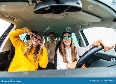 Group Of Girls Having Fun In The Car Singing Songs And Dancing In Car During Road Trip Stock